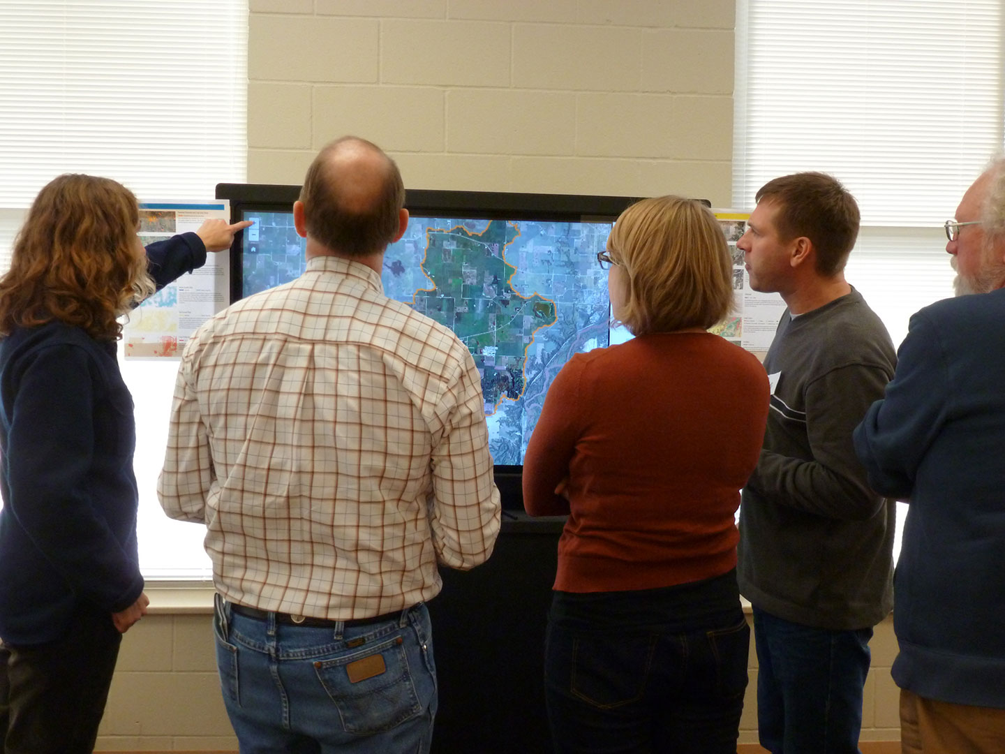 Group of stakeholders working around a 55” touchscreen